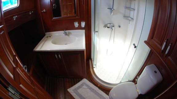 An elegant bathroom on the Gulet Sahinoğlu with a modern shower, washbasin and toilet.